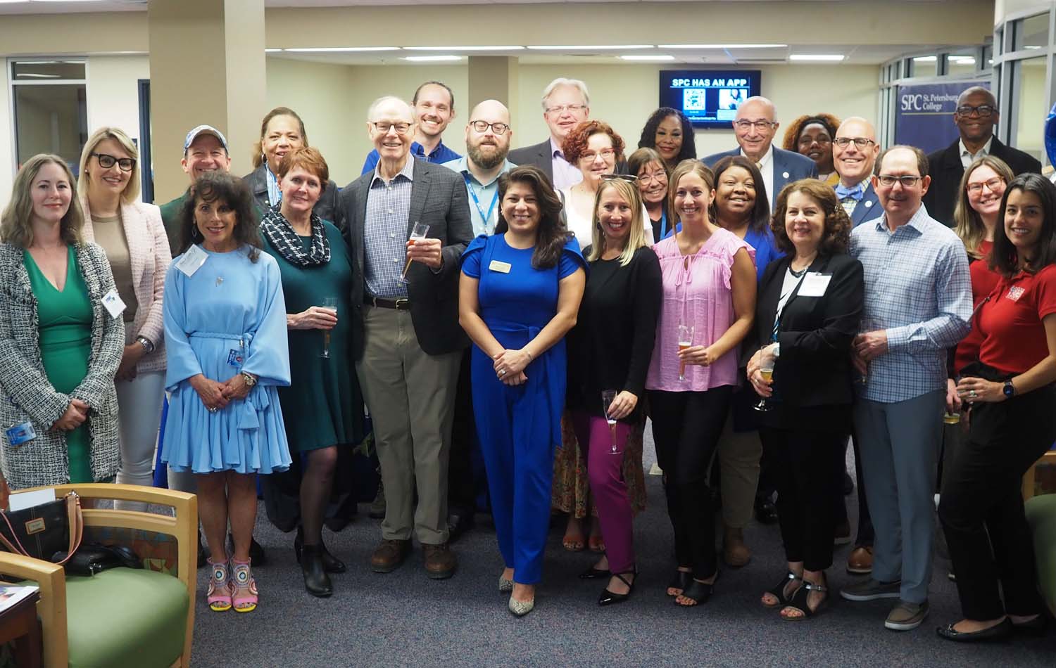 a gathering of attendees facing the camera and smiling