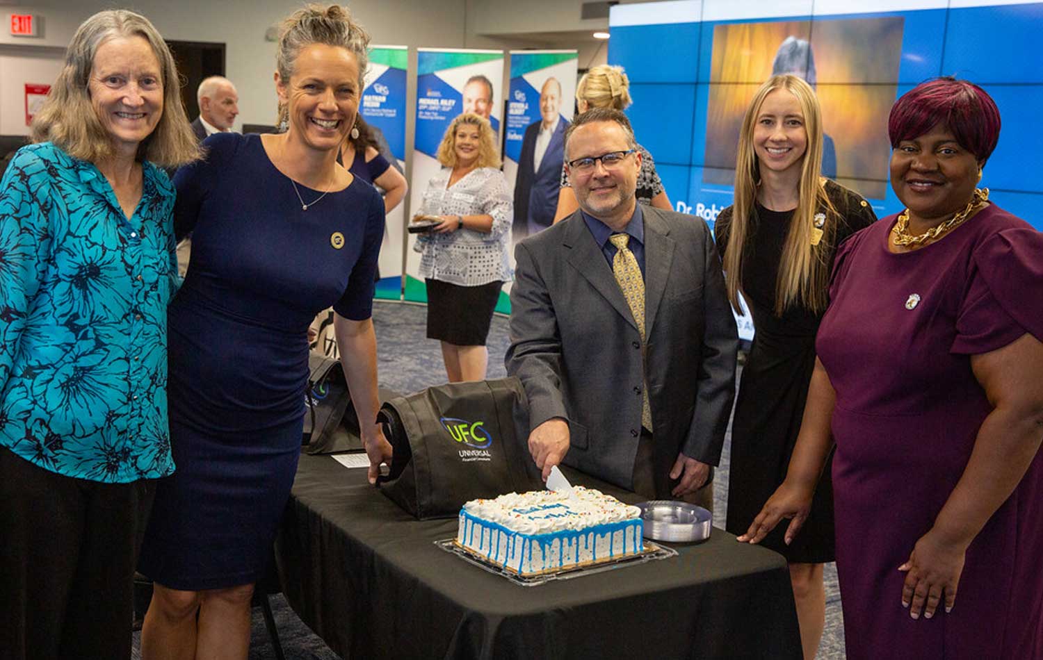 SPC employees smiling and cutting a cake