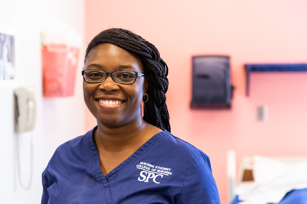 female SPC nursing student smiling wearing blue scrubs