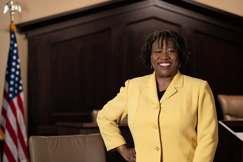 SPC student female student in yellow business suit in front of a court bench