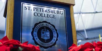 a photo of the SPC podium and seal surrounded by flowers at a graduation event