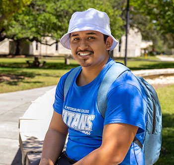 male stueent wearing a blue SPC ts-shirt and a white boat hat