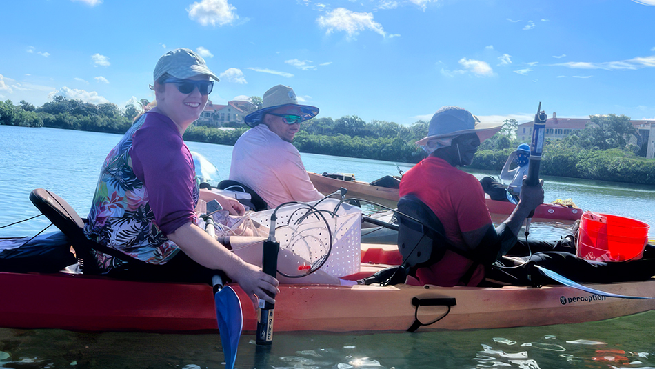 Professor Stephanie Palomino and two students in red and orange kayak