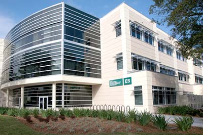 The SPC Clearwater Campus's modern-looking Ethics and Social Sciences building behind beautiful landscaping.