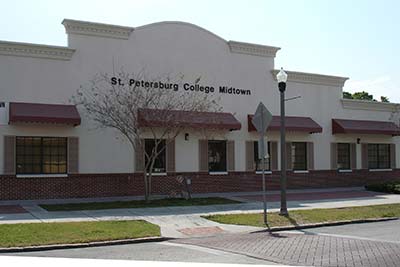 The SPC Epi-Services building pictured behind tall oak trees, with the blue SPC sign in the foreground.