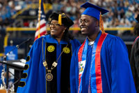 Dr. Williams congratulating SPC graduate wearing regalia